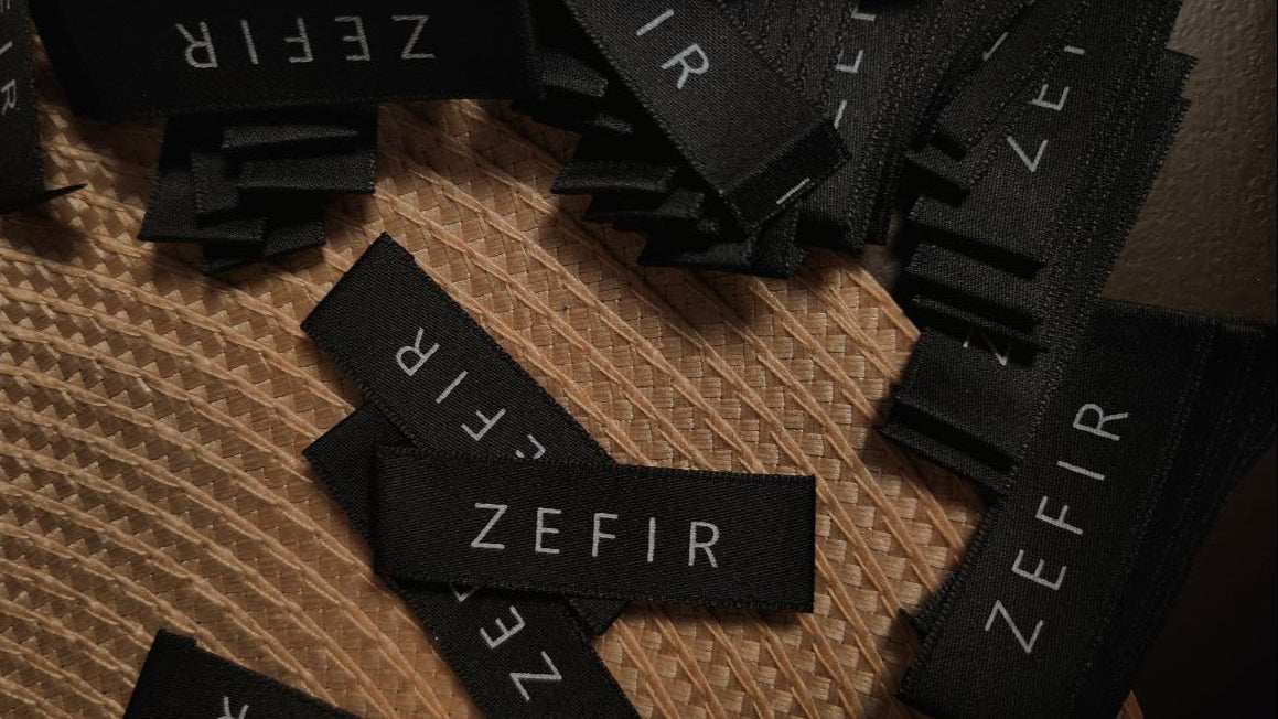 Black 'Zefir' labels scattered on a textured surface
